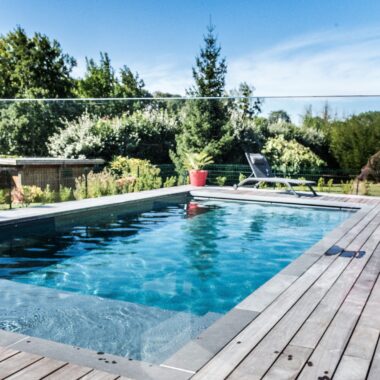 Jardin avec piscine, plantations, terrasse en bois et mobilier