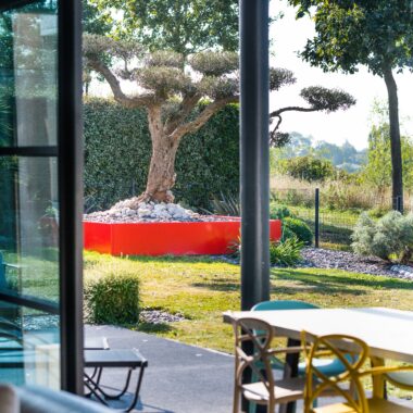 Jardin avec une terrasse en grès cérame, des plantations et du mobilier